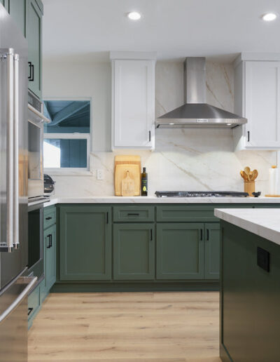 Sage green kitchen with white upper cabinets and range hood, San Jose, CA